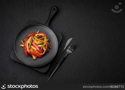 Delicious vegetables steamed peppers, asparagus beans and potatoes sliced with soy sauce on a dark concrete background