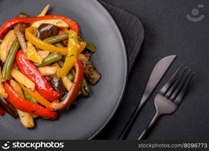 Delicious vegetables steamed peppers, asparagus beans and potatoes sliced with soy sauce on a dark concrete background