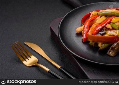 Delicious vegetables steamed peppers, asparagus beans and potatoes sliced with soy sauce on a dark concrete background