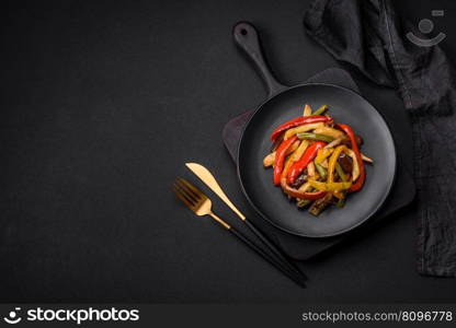 Delicious vegetables steamed peppers, asparagus beans and potatoes sliced with soy sauce on a dark concrete background