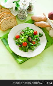 delicious vegetarian salad on green wooden table illuminated by day light