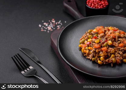 Delicious veggie salad with canned tuna and mexican vegetable mix on dark concrete background