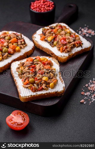 Delicious veggie sandwiches with canned tuna and Mexican mixed vegetables on a dark concrete background