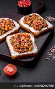 Delicious veggie sandwiches with canned tuna and Mexican mixed vegetables on a dark concrete background