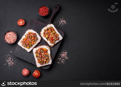 Delicious veggie sandwiches with canned tuna and Mexican mixed vegetables on a dark concrete background