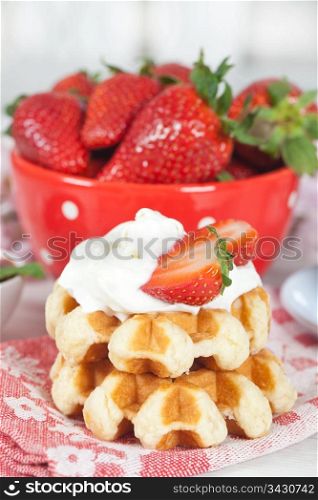 Delicious waffle with whipped cream and strawberries
