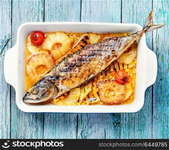 Delicious whole baked fish. Baked fish with pineapple and mango in pan