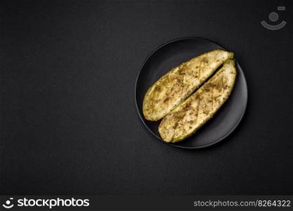 Delicious zucchini cut into two halves baked with salt, spices and herbs on a dark concrete background