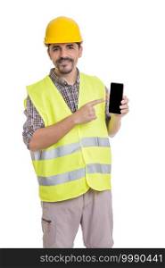 Delighted male builder in uniform standing on white background and pointing at screen of mobile phone while looking at camera. Cheerful male engineer with smartphone