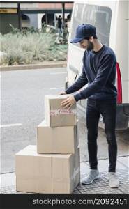 deliver man looking stacked cardboard boxes