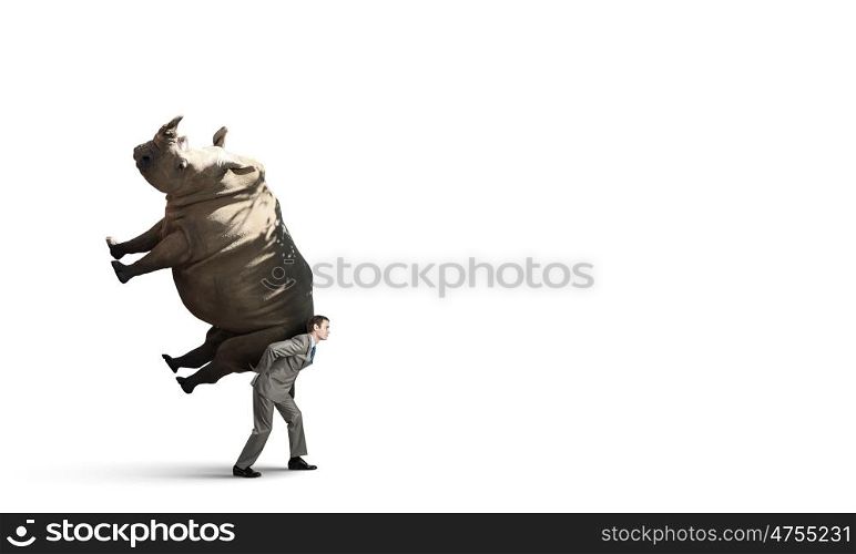 Delivering service. Tired businessman carrying rhino on his back