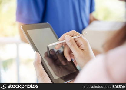 Delivery courier service man deliver package box to woman customer. Mailman shipment holding cardboard package box. Close Up hand receiver signing signature on digital tablet in coronavirus quarantine