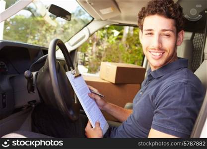 Delivery Driver Sitting In Van Filling Out Paperwork