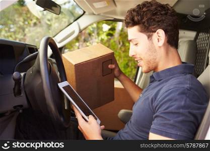 Delivery Driver Sitting In Van Using Digital Tablet
