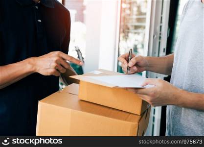 Delivery employee transport parcels pointing to documents for customers to receive products.