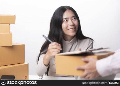 Delivery guy holding package while woman is signing documents
