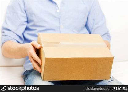 delivery, mail and people concept - close up of man with cardboard box or parcel at home