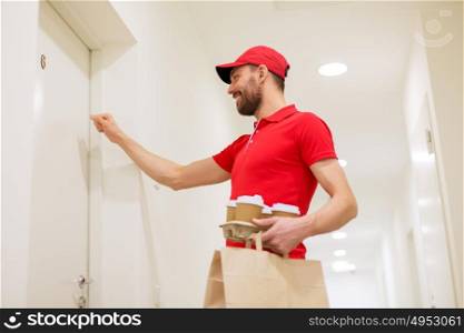 delivery, mail and people concept - happy man delivering coffee and food in disposable paper bag to customer home and knocking on door. delivery man with coffee and food knocking on door