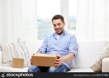 delivery, mail and people concept - happy man with cardboard boxes or parcels at home