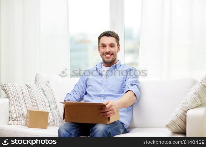 delivery, mail and people concept - happy man with cardboard boxes or parcels at home