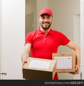 delivery, mail, people and shipment concept - happy man in red uniform with parcel boxes at open customer door. delivery man with parcel boxes at customer door