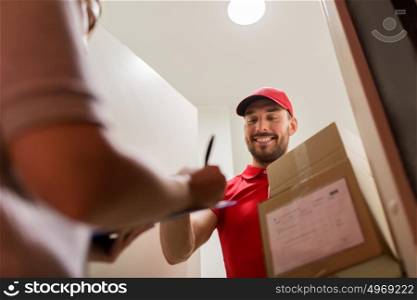 delivery, mail, people and shipping concept - happy man with clipboard delivering parcel boxes to customer signing form at home. deliveryman and customer with parcel boxes at home