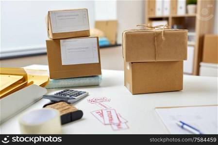 delivery, mail service and shipment concept - parcel boxes with postal forms on table at post office. parcel boxes on table at post office