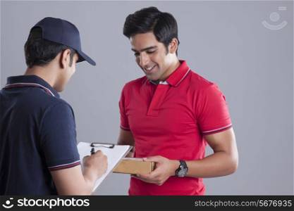 Delivery man and customer with package over gray background