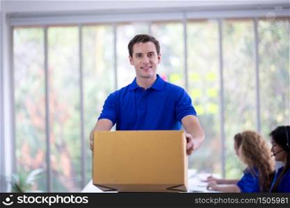 delivery man blue t-shirt holding box in call center office
