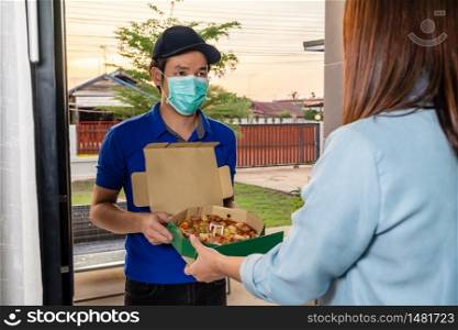 Delivery man delivering pizza food to customer woman at home, people must wear a mask to prevent the spread of coronavirus (Covid-19)