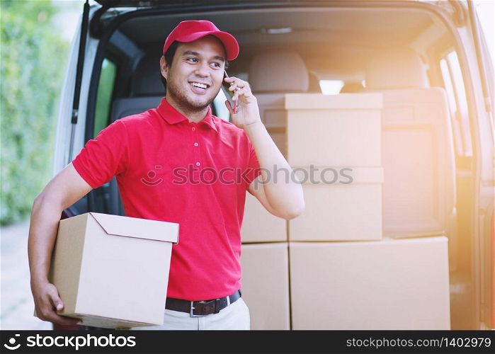 Delivery man employee in red cap t-shirt uniform mask glove hold craft paper packet