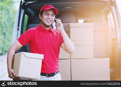 Delivery man employee in red cap t-shirt uniform mask glove hold craft paper packet