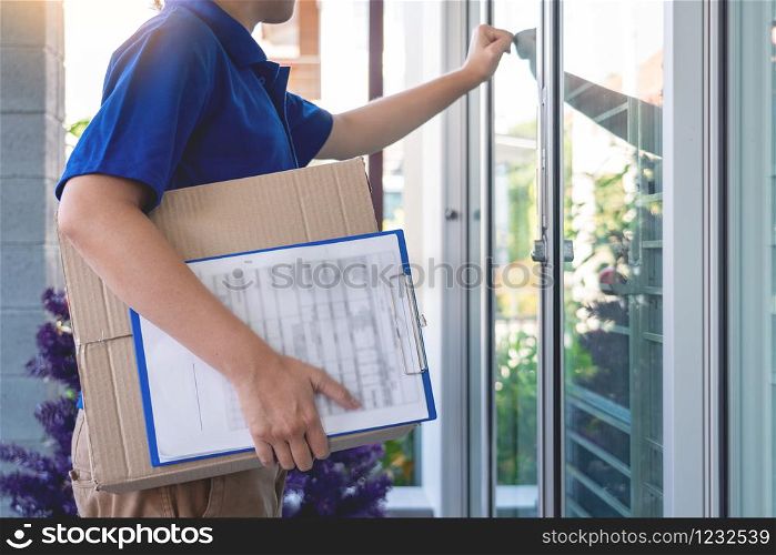 Delivery man in blue uniform handing parcel box for client signing checklist after confirm receiving package