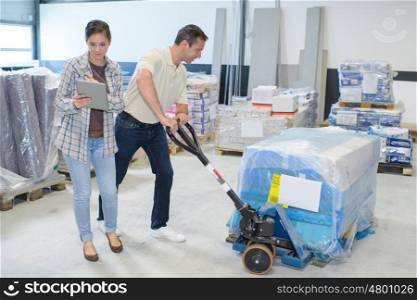 delivery man with trolley getting orders from female manager