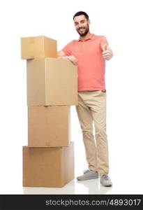 delivery, moving, people and logistics concept - happy man with pile of cardboard boxes showing thumbs up