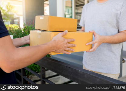 delivery service concept, customer hand receiving a cardboard boxes parcel from delivery man at home