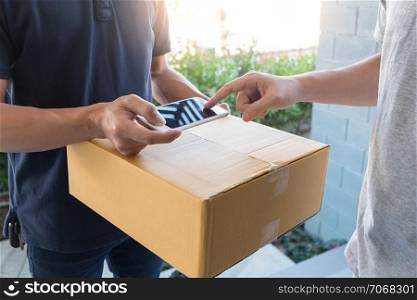 delivery service concept, customer hand receiving a cardboard boxes parcel from delivery man at home