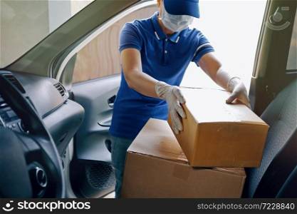 Delivery services courier during the Coronavirus (COVID-19) pandemic, courier wearing medical mask and latex gloves for safety protection from virus infection working with cardboard boxes on van seat.