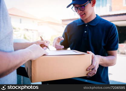 Delivery young man standing at the door of home and carrying parcels for young male to signing.