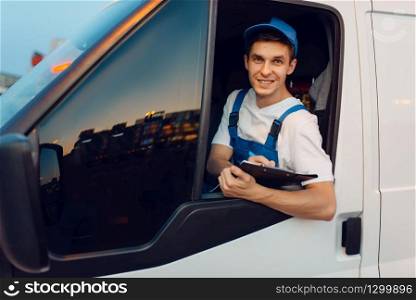 Deliveryman in uniform drives a car, delivery service, delivering. Man in post vehicle, male deliver, courier or shipping job