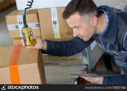 deliveryman in warehouse loading cardboard boxes into truck