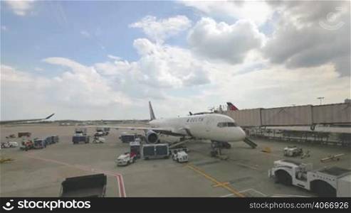 Delta Airlines plane refueling and all airport services preparing flight. Video time lapse preparing the aircraft for next takeoff in the United States of America. Filling the tank of kerosene, putting luggage in the trunk and preparing the flight catering.