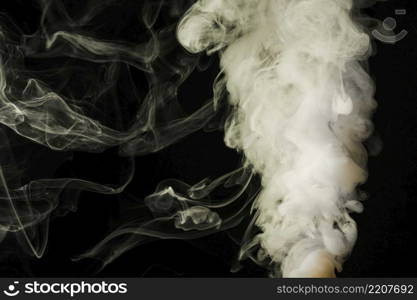 dense fluffy puffs white smoke black background