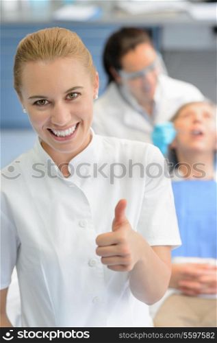 Dental assistant dentist checkup patient woman at professional clinic thumbup