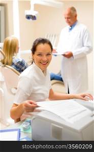 Dental assistant smiling woman prepare patient documentation stomatology clinic