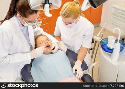 Dental assistant with dentist female and little child at stomatology surgery