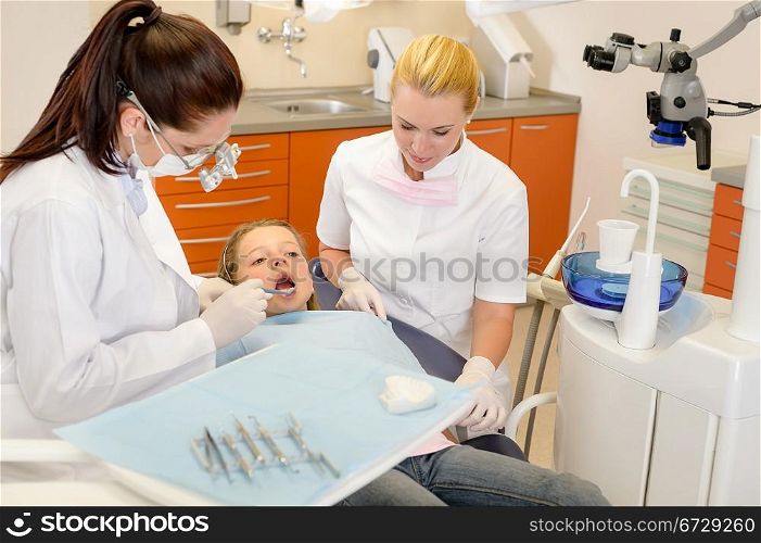 Dental assistant with dentist female and little child at stomatology surgery