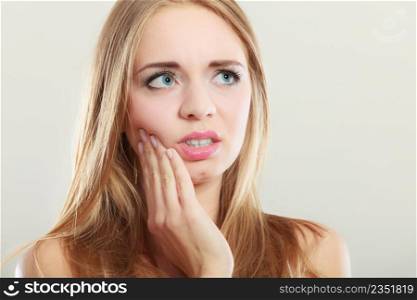 Dental care and toothache. Closeup young woman face worried girl suffering from tooth pain