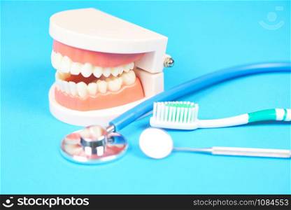 Dental care concept / dentist tools with dentures dentistry instruments and dental hygiene and equipment checkup with teeth model and mouth mirror oral health