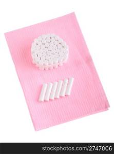 dental cotton rolls on a pink bib (isolated on white background)